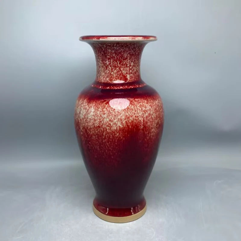 Vase en céramique de couleur rouge avec des motifs texturés, créant un effet de surface vitrifiée.