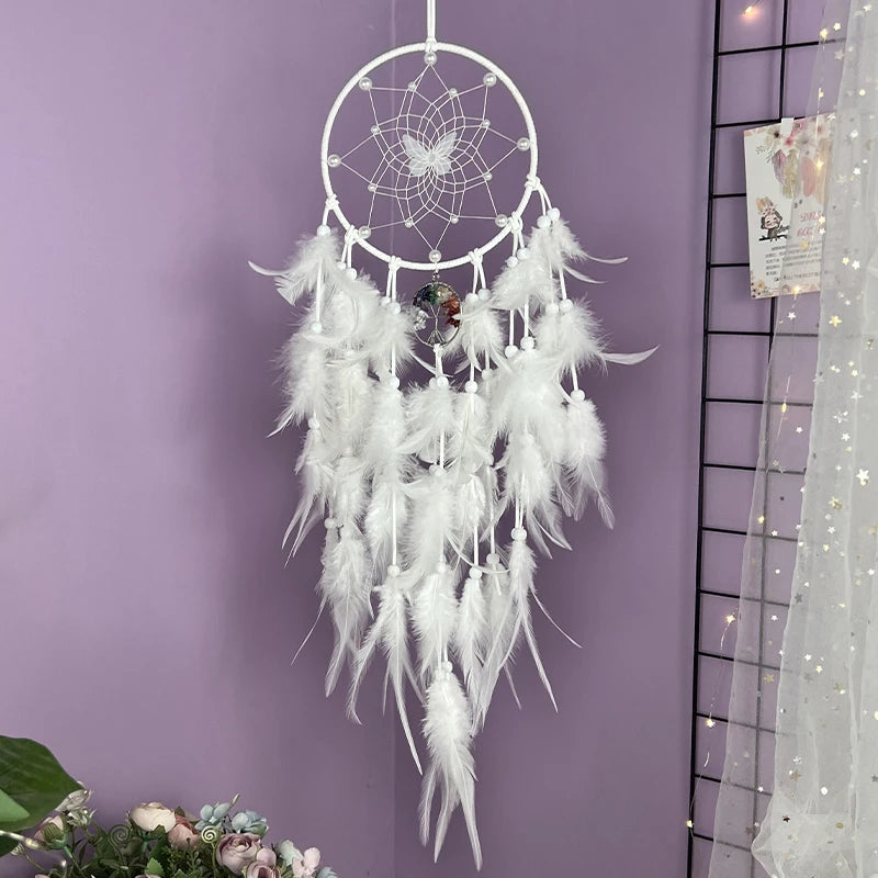 Captivant attrape-rêves blanc aux motifs délicats et plumes légères, suspendu sur un mur violet, créant une ambiance sereine.