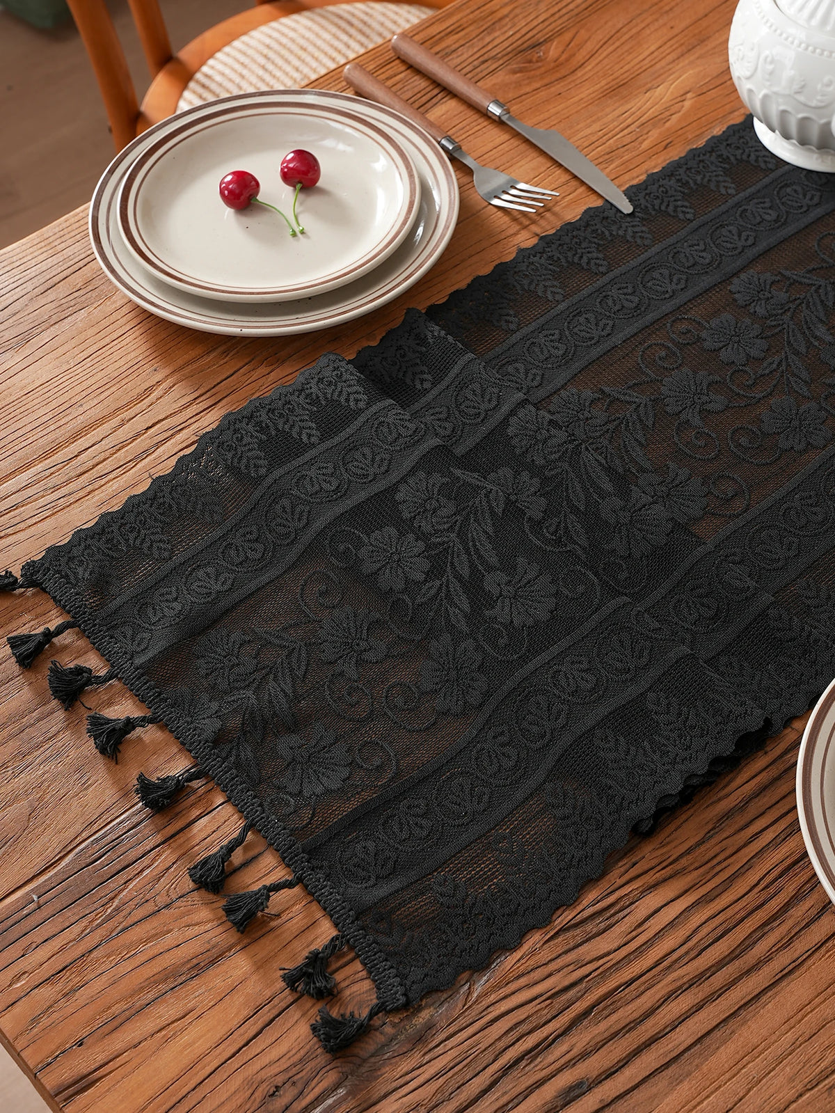 chimene table noir dentelle motif floral bordures franges assiettes couverts tasse théière gâteau cerises