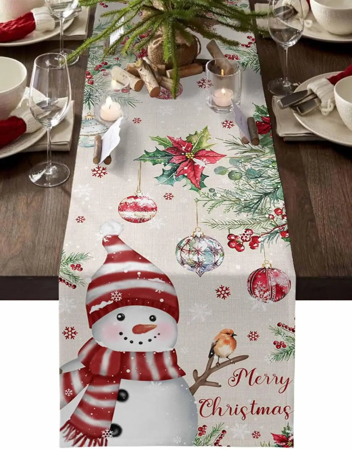 Cette image montre une belle table de Noël avec une nappe décorée de motifs de Noël comme des boules de Noël, des branches de sapin, des fleurs de Noël rouges et un bonhomme de neige.