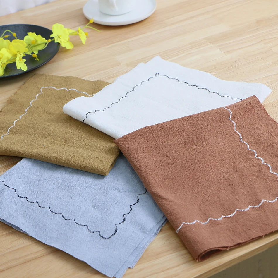 Serviettes de toilette en tissu doux avec motifs géométriques et floraux, posées sur une surface en bois.
