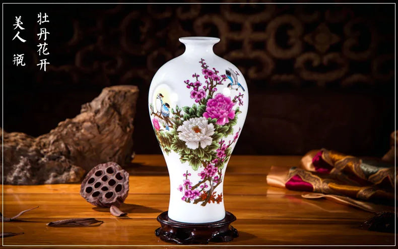 Un vase blanc orné de fleurs et d'oiseaux colorés, posé sur un support en bois avec un lotus séché à côté, représente l'artisanat et la beauté traditionnels chinois.