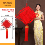 guirlande traditionnelle chinoise tissée artisanale rouge motifs géométriques pompon ruban doré festive printemps
