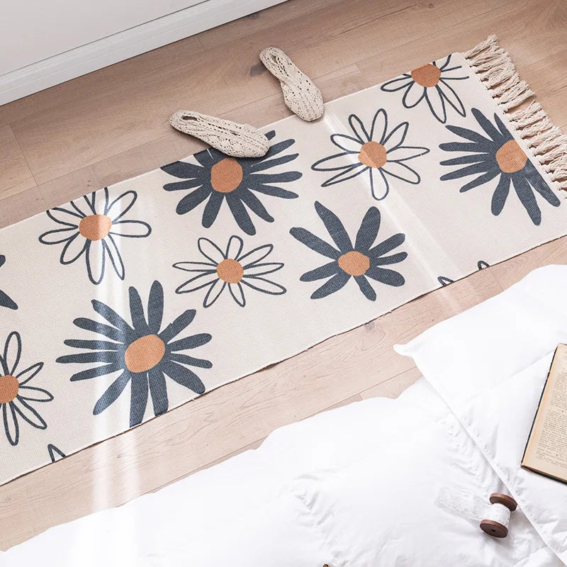 Un tapis de sol décoré avec de jolis motifs de fleurs bleues et orange, posé sur un sol en bois clair.