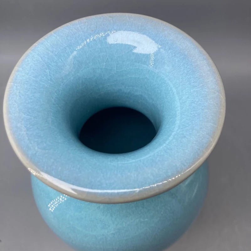 Un design cylindrique bleu clair avec un trou noir en son centre, évoquant une forme harmonieuse et épurée.