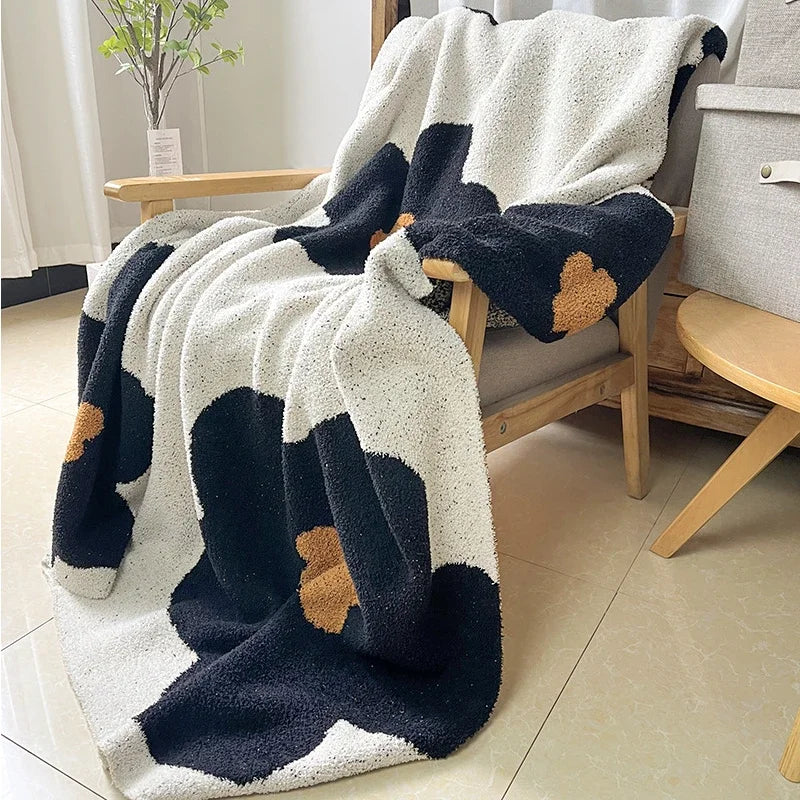 Couverture moelleuse et confortable avec un motif géométrique noir et blanc, parfaite pour un moment de détente et de cocooning.