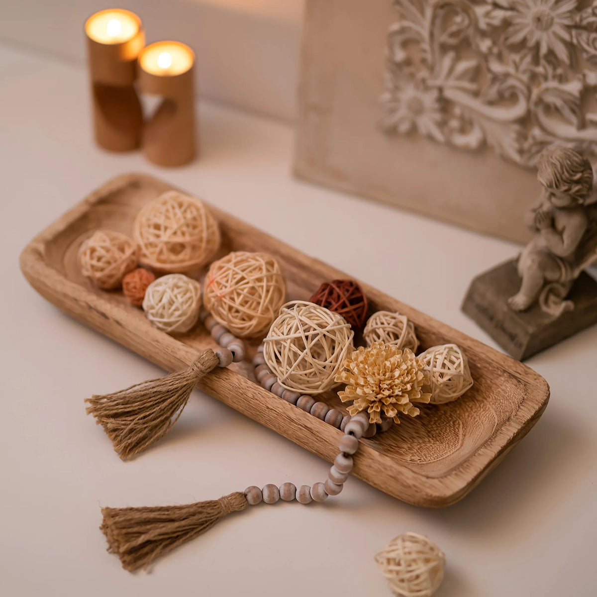 plateau décoratif bois marron clair boules fibres naturelles bougies translucides guirlande tassels fleurs artificielles