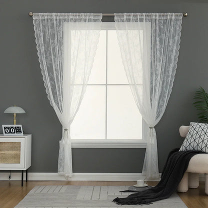 Voilage blanc en dentelle encadrant une grande fenêtre dans un salon cosy aux murs gris.