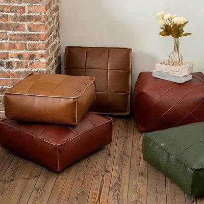 Pouf marocain en cuir PU brodé de couleur bordeaux sur un sol en bois