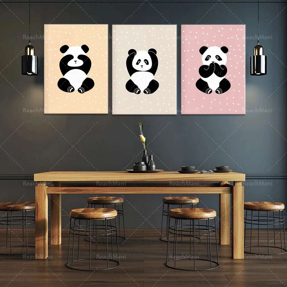 Affiches décoratives mignons avec des images de pandas assis sur un fond rose et beige, montées sur un mur gris foncé au-dessus d'une table en bois et de tabourets noirs, créant un bel ensemble décoratif pour une cuisine ou une salle à manger.