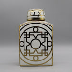 Cette image montre un vase décoratif en porcelaine blanche et or avec des motifs géométriques complexes.