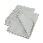 Serviettes de cuisine en lin gris, pliées et posées sur un fond blanc.