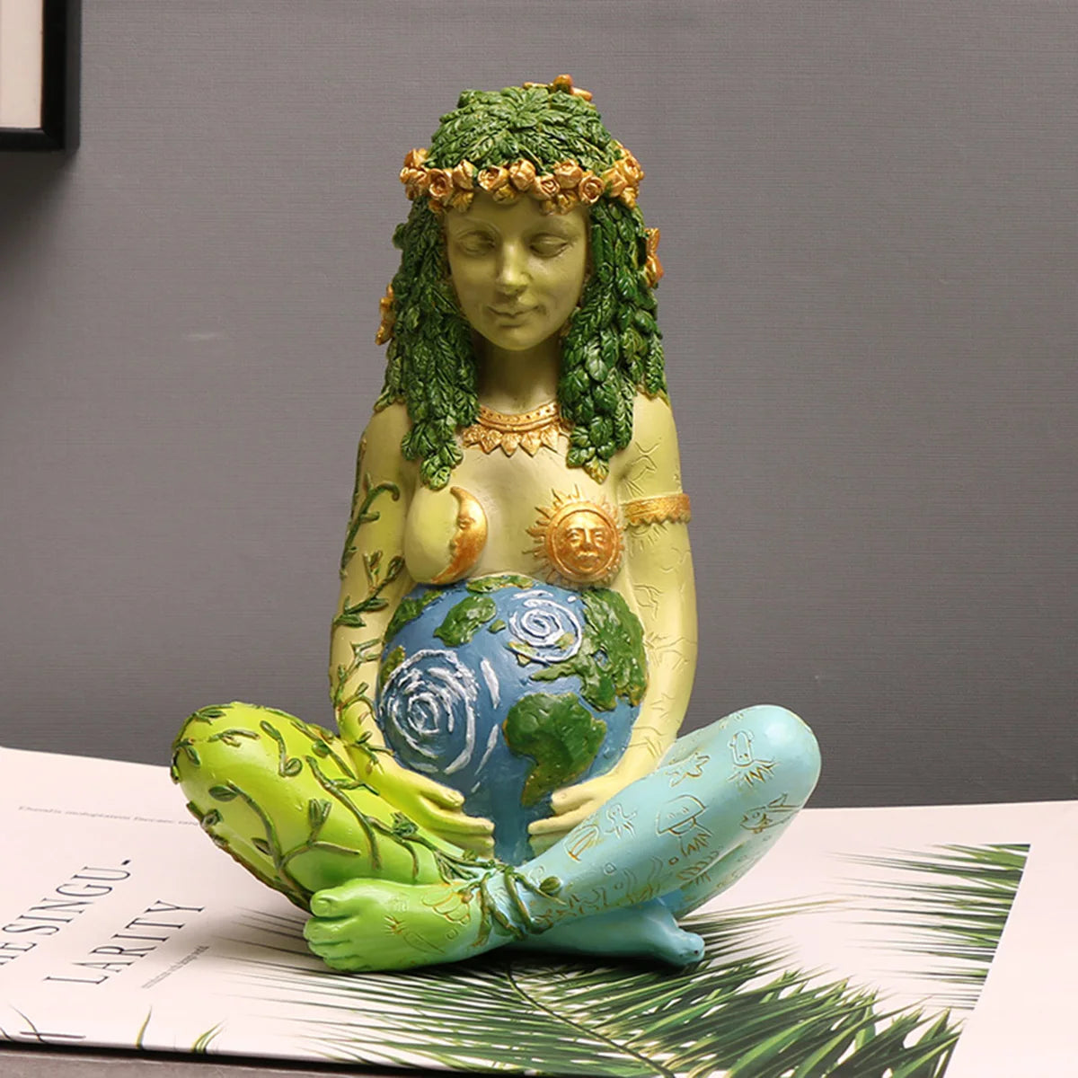 statuette verte déesse motifs floraux art nouveau globe terrestre textures organiques feuilles fleurs