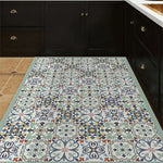 Carreaux de sol traditionnels en motifs floraux aux couleurs nuancées de gris, bleu et orange, créant un sol décoratif et élégant dans cette cuisine moderne.