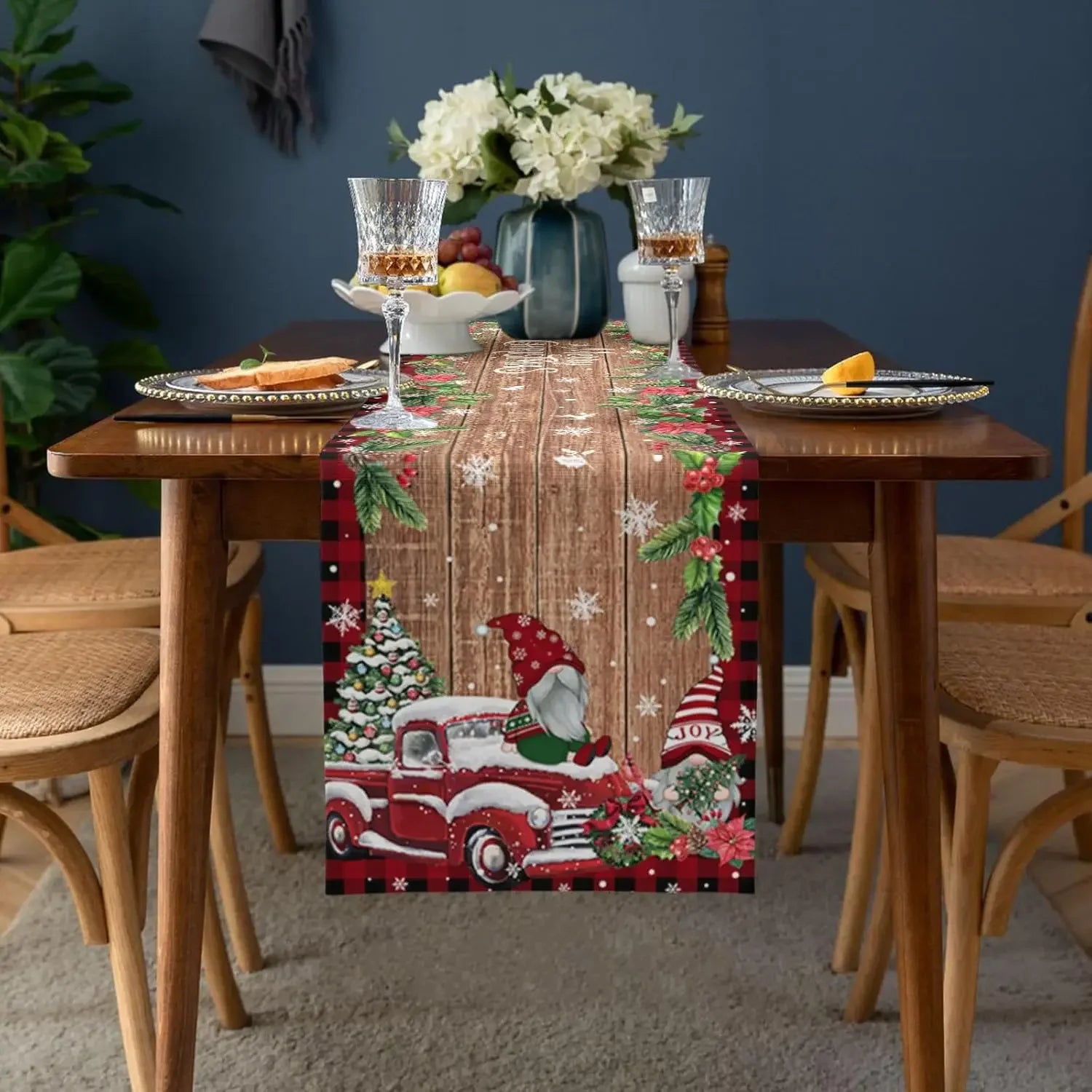 Cette nappe de table de Noël avec un motif d'un camion vintage rouge chargé de cadeaux et de décorations festives crée une atmosphère chaleureuse et conviviale dans la salle à manger.
