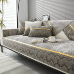 Ce sofa au design élégant et minimaliste présente des motifs géométriques en zigzag dans des tons de gris et d'or, créant une atmosphère apaisante et moderne dans cette pièce baignée de lumière naturelle.