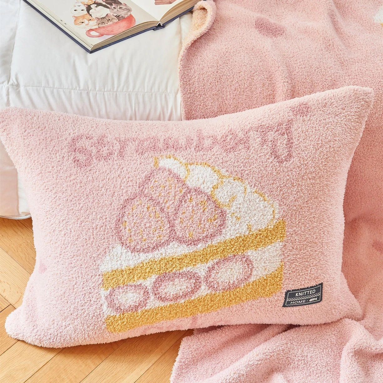 Oreiller en peluche rose pastel décoré de motifs abstraits dorés et blancs, offrant un confort douillet et une touche de style à la chambre.