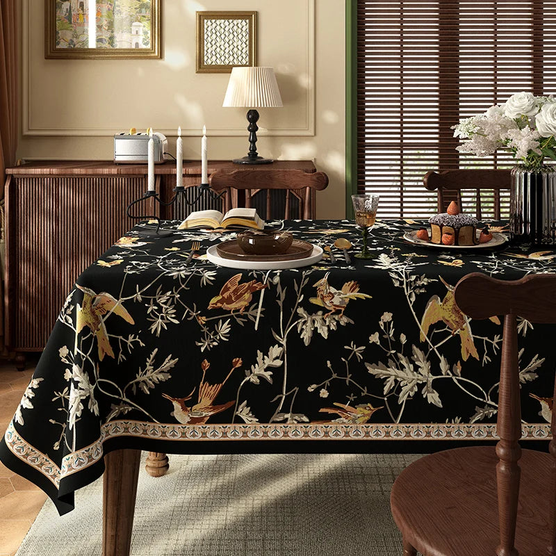 Une table de salle à manger richement décorée avec une nappe à motifs floraux et des accessoires harmonieux, créant une ambiance chaleureuse et élégante.