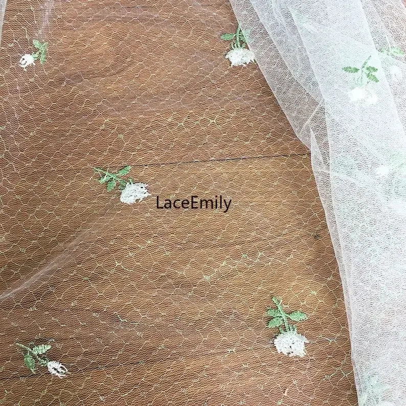 tissu dentelle transparent brodée motifs floraux roses feuilles romantique blanc rose vert