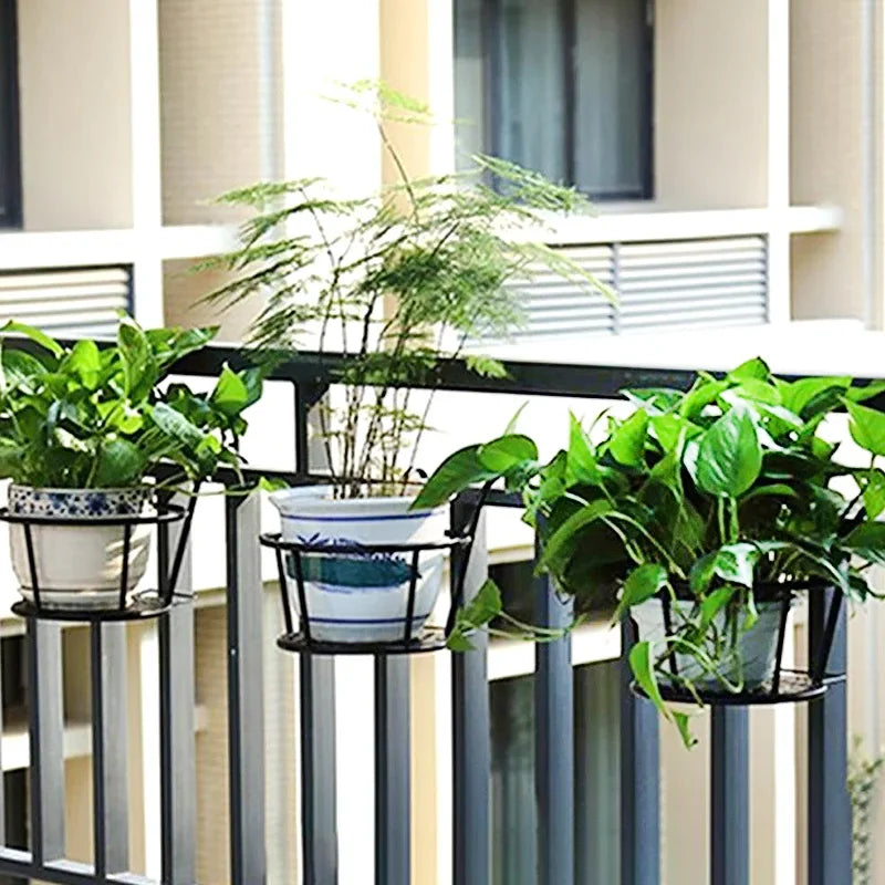 Jardinière rouge avec plante retombante sur balcon moderne