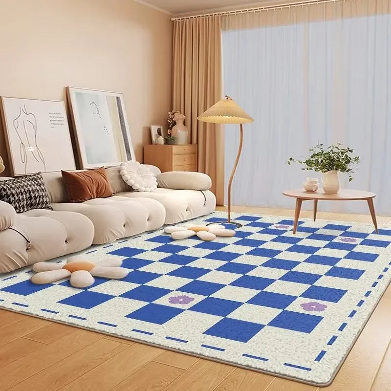 Un tapis de jeu avec un motif de carreaux bleus et blancs posé dans un salon confortable, avec un canapé beige, des décorations et une lampe de table, créant une ambiance cosy et chaleureuse pour les activités familiales.