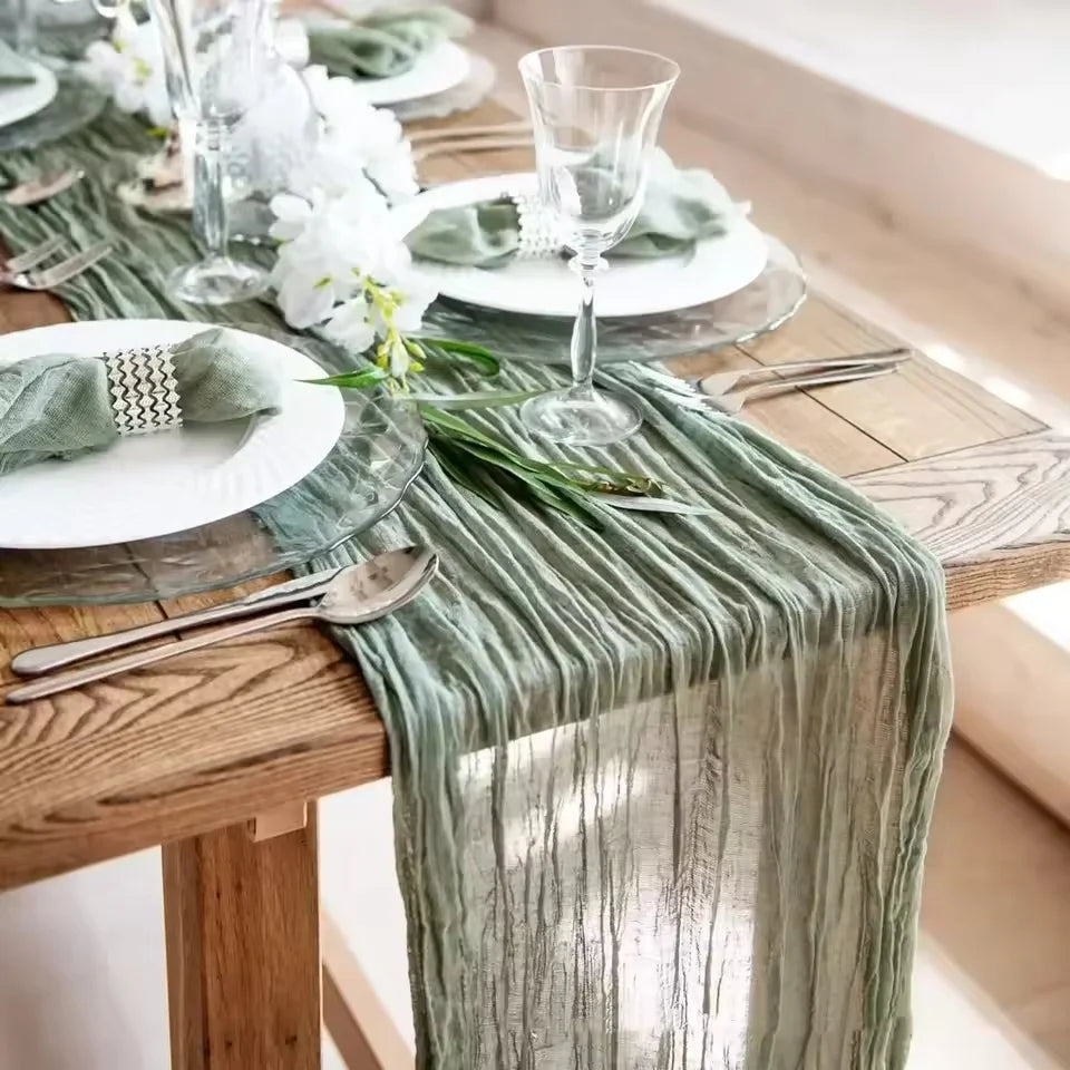serviette table vert plissée moderne assiettes blanches verres vin bougies vase blanc pompons blancs