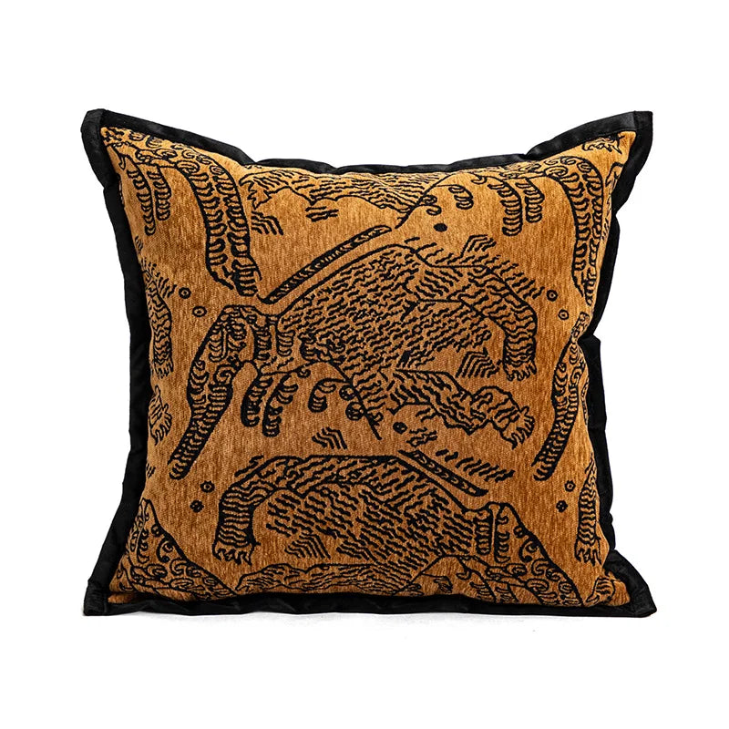 Coussin décoratif en velours avec motif animal ornemental en couleurs chaudes.