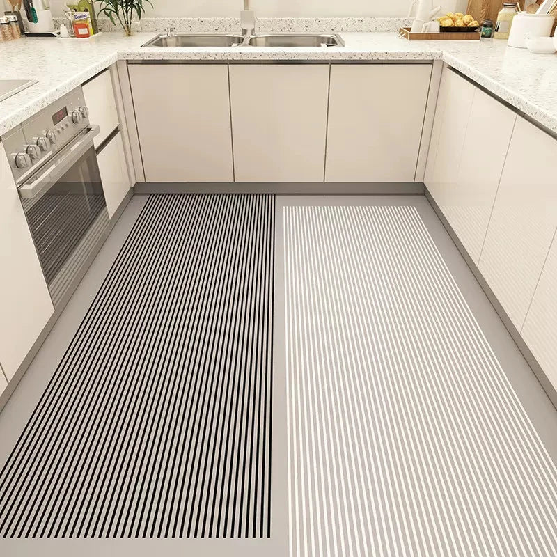 Cette image montre un intérieur de cuisine moderne avec deux tapis de sol à rayures noirs et blancs disposés côte à côte, créant un motif graphique et tendance.