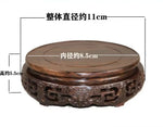 support circulaire bois sculpté artisanal traditionnel marron foncé détails complexes vase plantes décoration maison