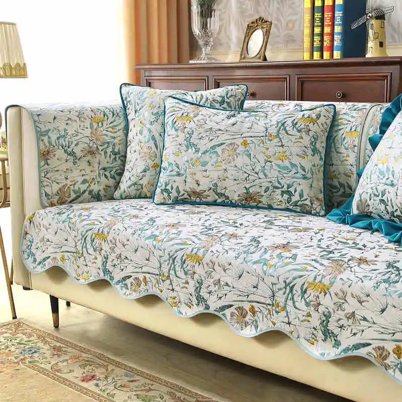 Le canapé est couvert d'un joli motif floral aux couleurs vives, créant une ambiance chaleureuse et relaxante dans la pièce.