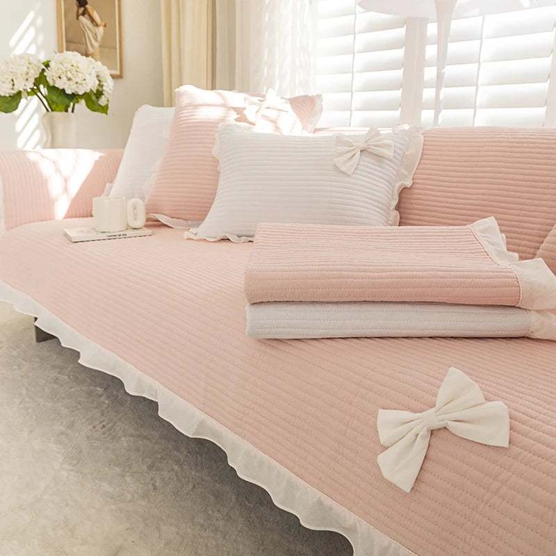 Une chambre de style romantique avec des draps roses délicatement plissés et des coussins assortis, créant une ambiance chaleureuse et apaisante.