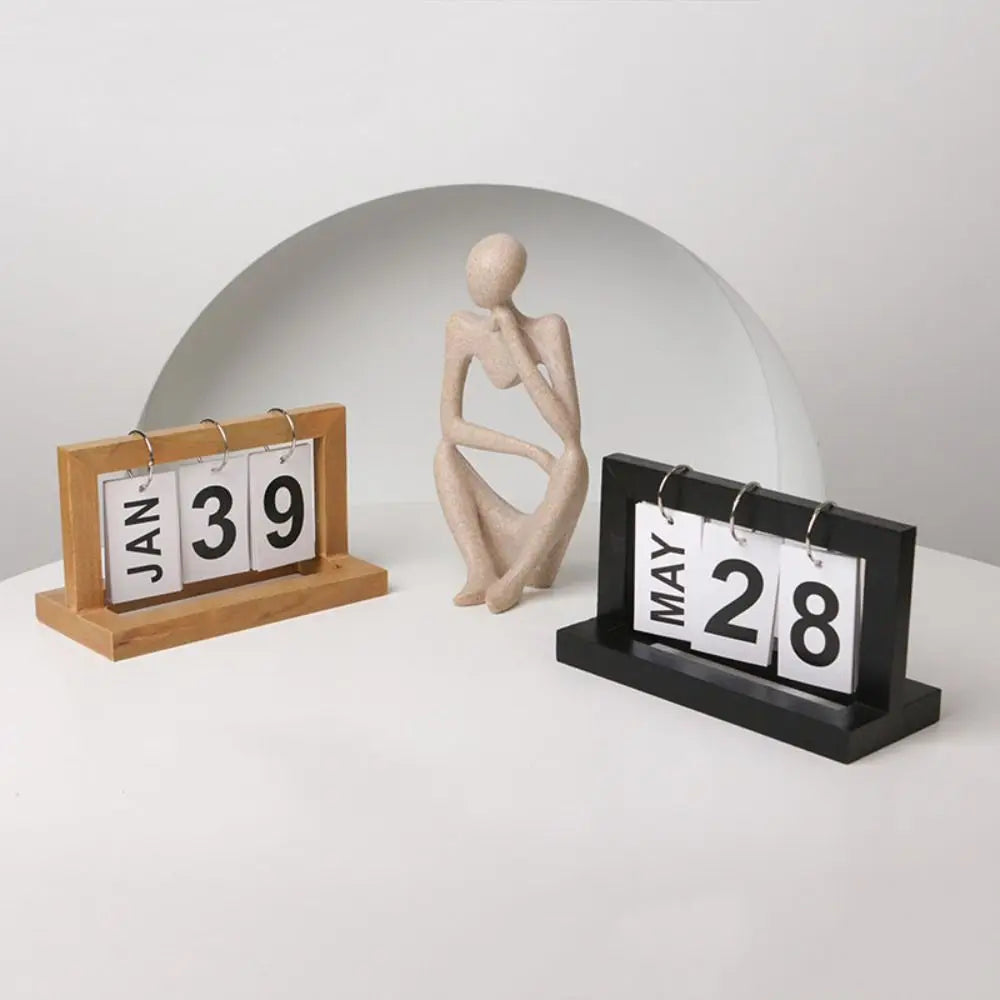 calendrier sculpture bois minimaliste moderne chiffres coulissants personne assise buste sphères blancs