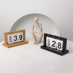 calendrier sculpture bois minimaliste moderne chiffres coulissants personne assise buste sphères blancs