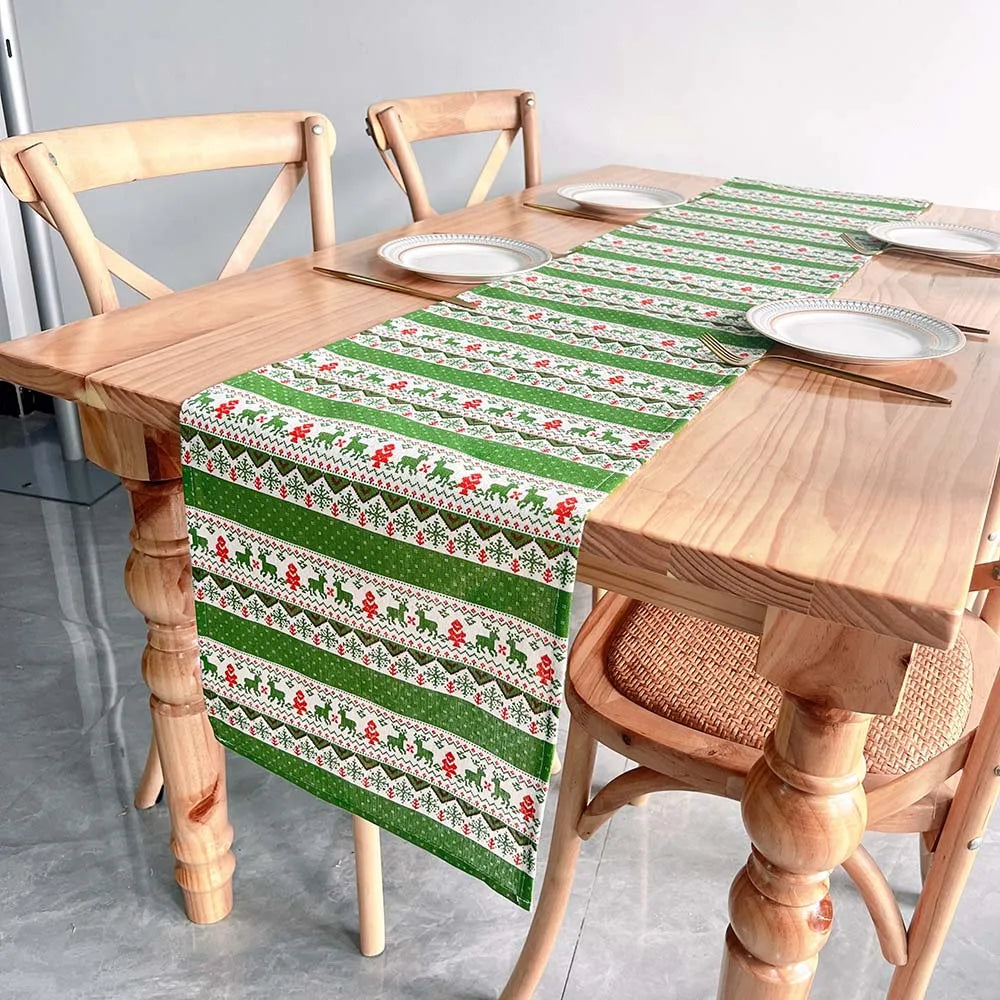 Décorez votre table avec ce chemin de table festif vert et blanc orné de motifs traditionnels et de silhouettes d'animaux.