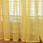 Détail du tissu translucide du rideau voile jaune en lumière naturelle