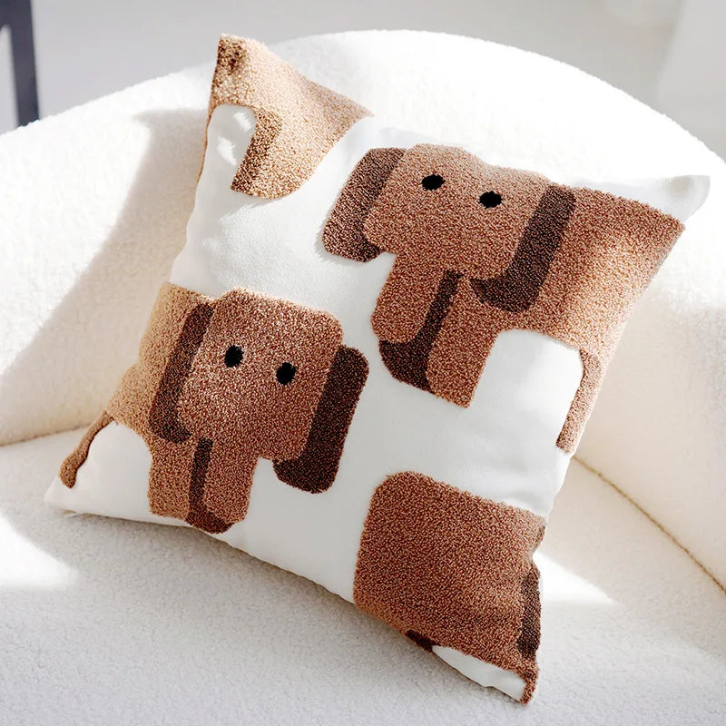 Coussin décoratif orné de motifs d'éléphants mignons et moelleux sur un fond blanc.
