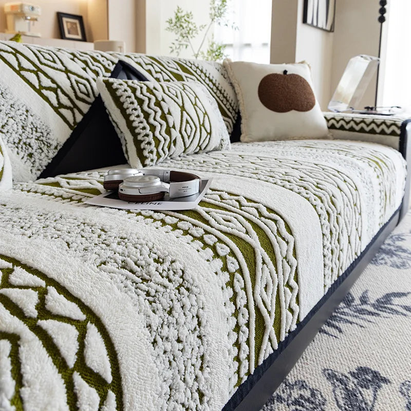 Un lit douillet avec une couverture texturée aux motifs géométriques blancs et verts, décoré de coussins et d'un plateau avec des objets décoratifs, créant une ambiance cosy et confortable dans cette chambre.