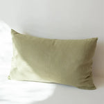 Coussin décoratif rectangulaire de couleur vert olive, sur fond blanc.