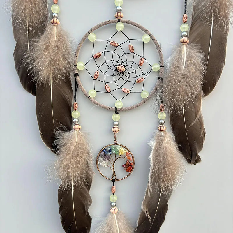Superbe décoration murale artisanale composée d'un capteur de rêves en macramé orné de perles, de plumes et d'un pendentif en forme d'arbre de vie multicolore, suspendu à des branches de fourrure.