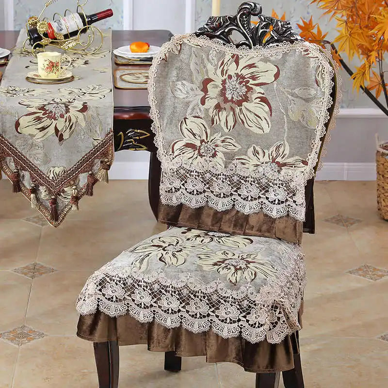 Chaises recouvertes de motifs floraux élégants et de dentelle décorative, installées autour d'une table avec des accessoires vintage, créant une ambiance raffinée.