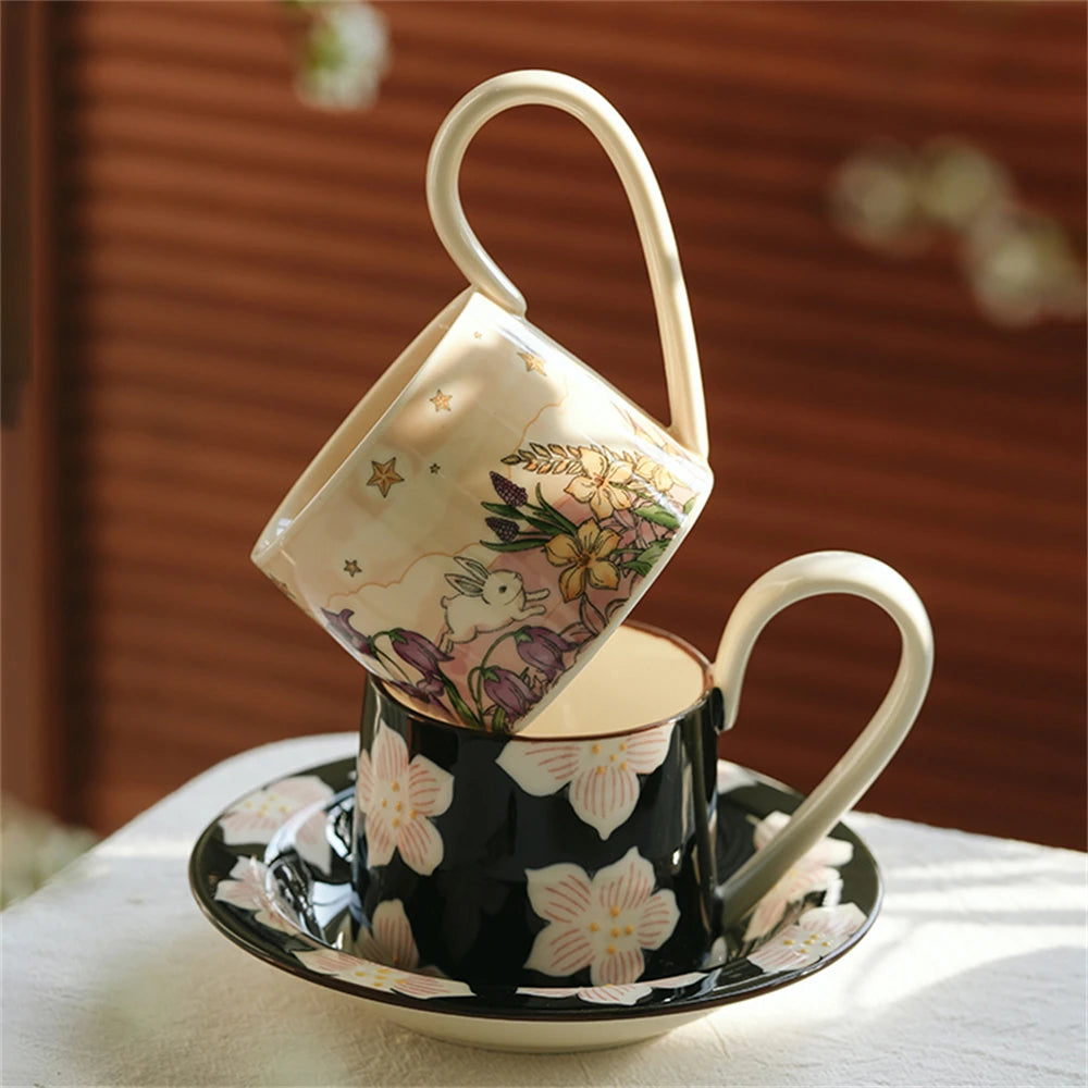 Une tasse de thé en céramique décorée de fleurs et d'un lapin, posée sur une soucoupe assortie, créant une atmosphère chaleureuse et printanière.