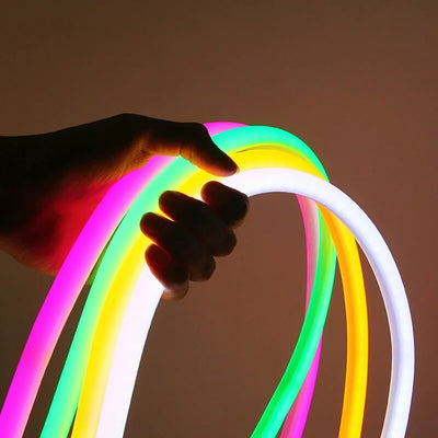 Tube néon LED rond flexible bleu installé en forme de vague sur mur blanc