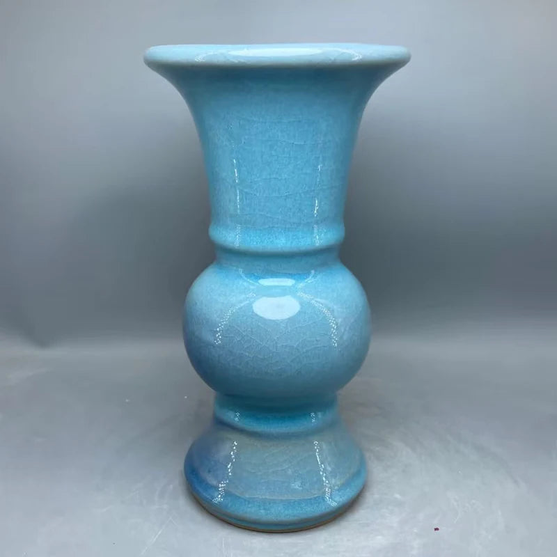 Vase décoratif en céramique de couleur bleu turquoise avec une finition brillante et un design élégant.