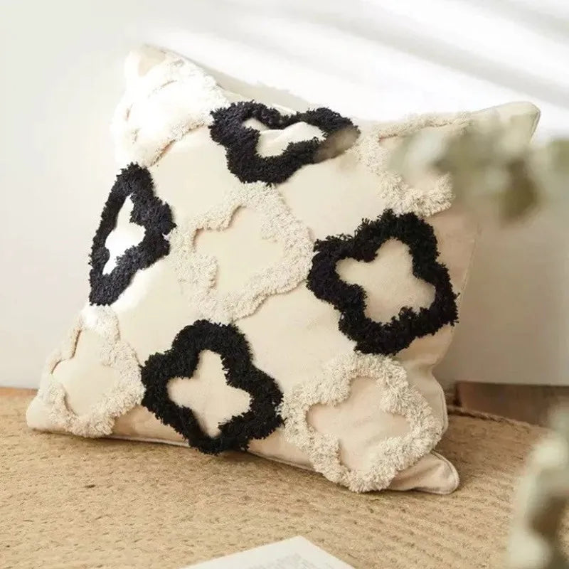 Coussin décoratif en peluche blanche avec des motifs de cœurs noirs donnant un aspect soyeux et moelleux.