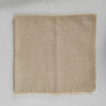 Couverture de luxe en lin beige avec des franges sur les bords, idéale pour la décoration d'intérieur.