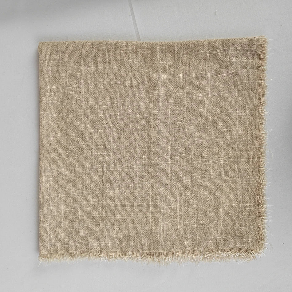 Couverture de luxe en lin beige avec des franges sur les bords, idéale pour la décoration d'intérieur.