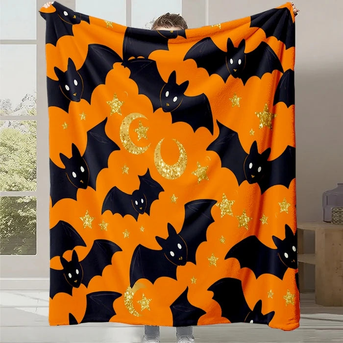 Couverture orange à motifs de chauves-souris noires et brillantes, parfaite pour décorer un espace festif d'Halloween.