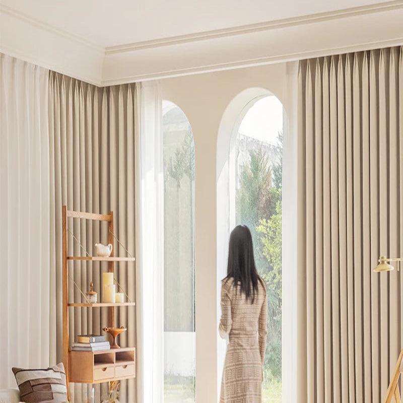 Rideaux élégants dans un salon spacieux, créant une ambiance lumineuse et accueillante. Idéal pour améliorer la décoration intérieure et ajouter une touche de sophistication à votre espace de vie.