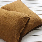 Un coussin de style loft avec une texture chiffonnée et des tons chauds de terre cuite.
