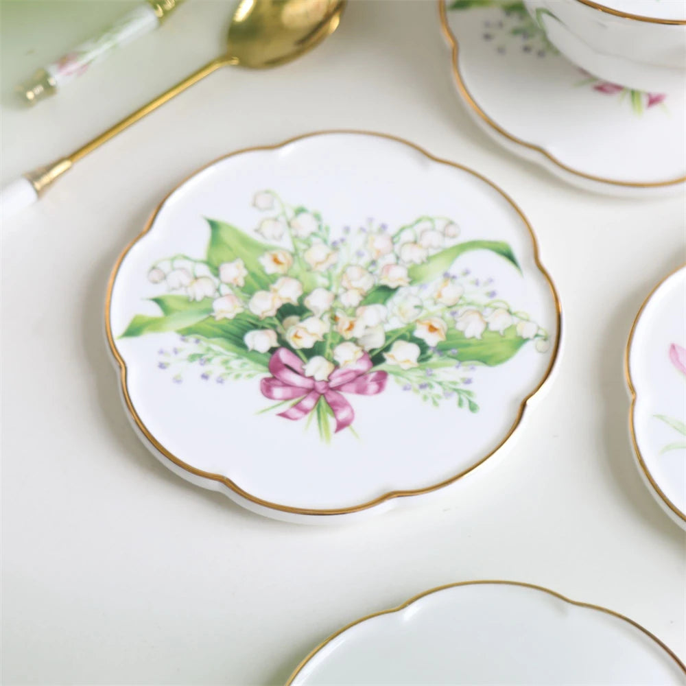 Assiette délicate avec un bouquet de fleurs de lys des vallées attachées par un ruban rose, sur un fond blanc avec une bordure dorée.